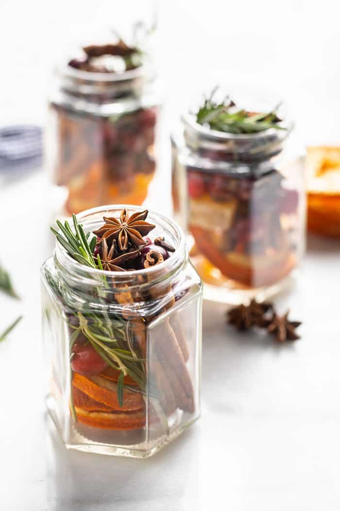 Three open glass jars filled with stovetop potpourri