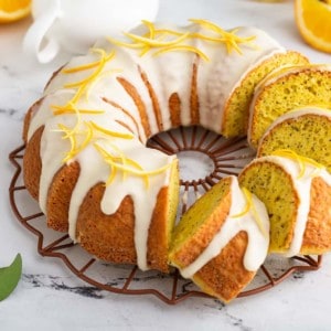 Sliced citrus poppy seed cake on a marble counter