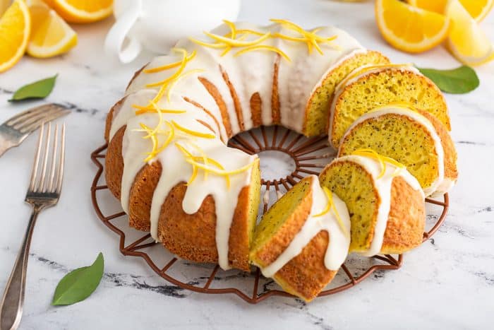 Sliced citrus poppy seed cake on a marble counter