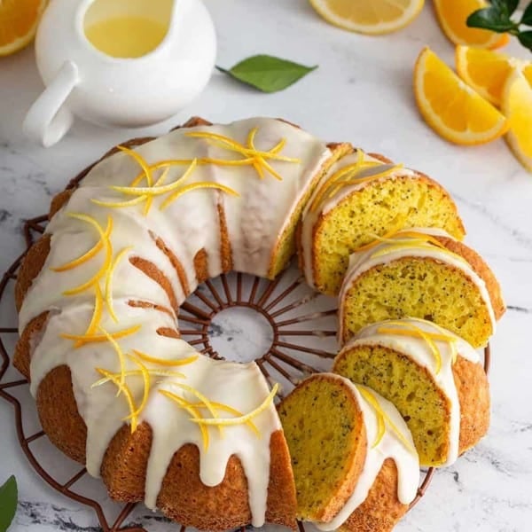 Sliced citrus poppy seed cake topped with glaze and citrus zest