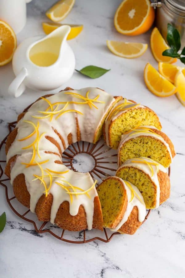 Sliced citrus poppy seed cake topped with glaze and citrus zest