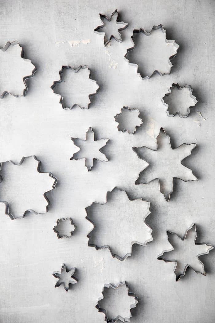 Assorted snowflake shaped cookie cutters arranged on a gray counter