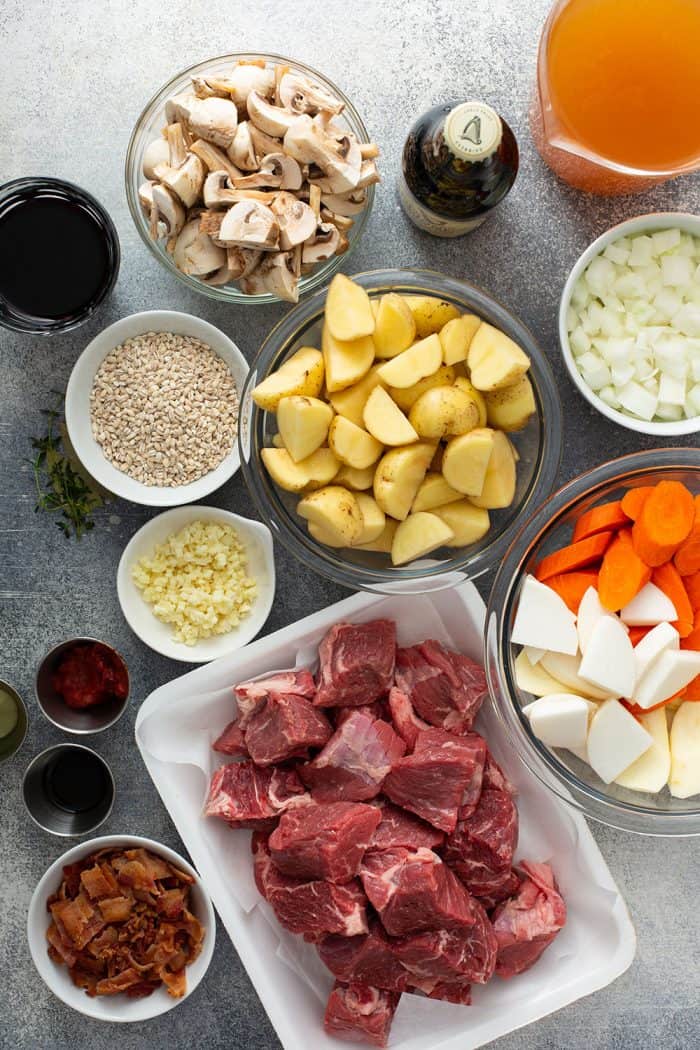 Ingredients for beef and barley stew arranged on a countertop