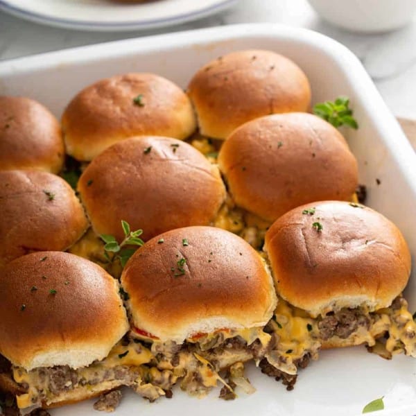 Side view of baked cheeseburger sliders in a baking dish to show the sides of the sliders