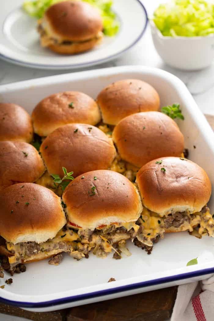 Side view of baked cheeseburger sliders in a baking dish to show the sides of the sliders