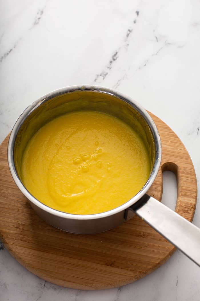 Simple egg custard in a saucepan on a wooden trivet