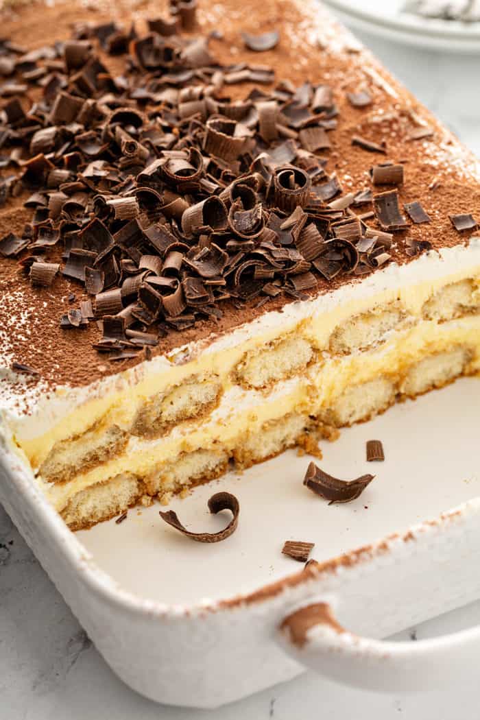 Cut tiramisu in a white baking dish