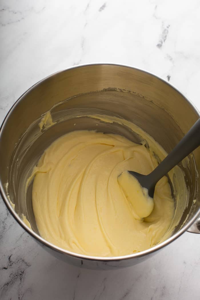 Spatula folding together mascarpone cream in a metal bowl