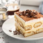 Cut slice of tiramisu on a white plate