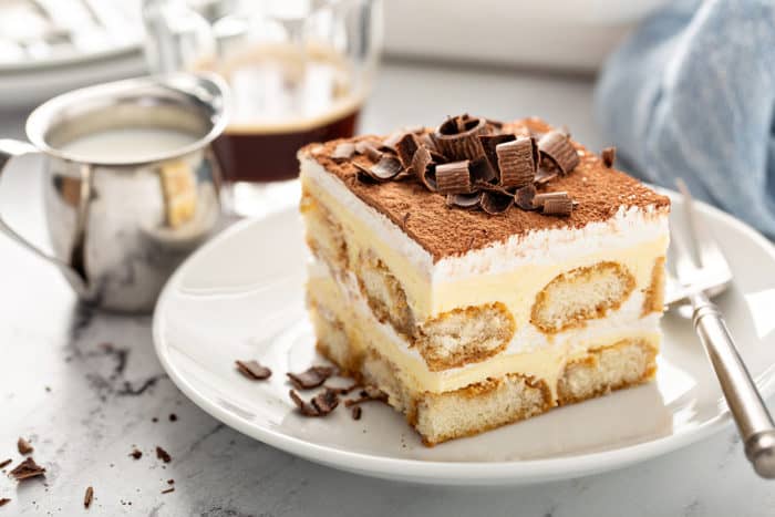 Cut slice of tiramisu on a white plate