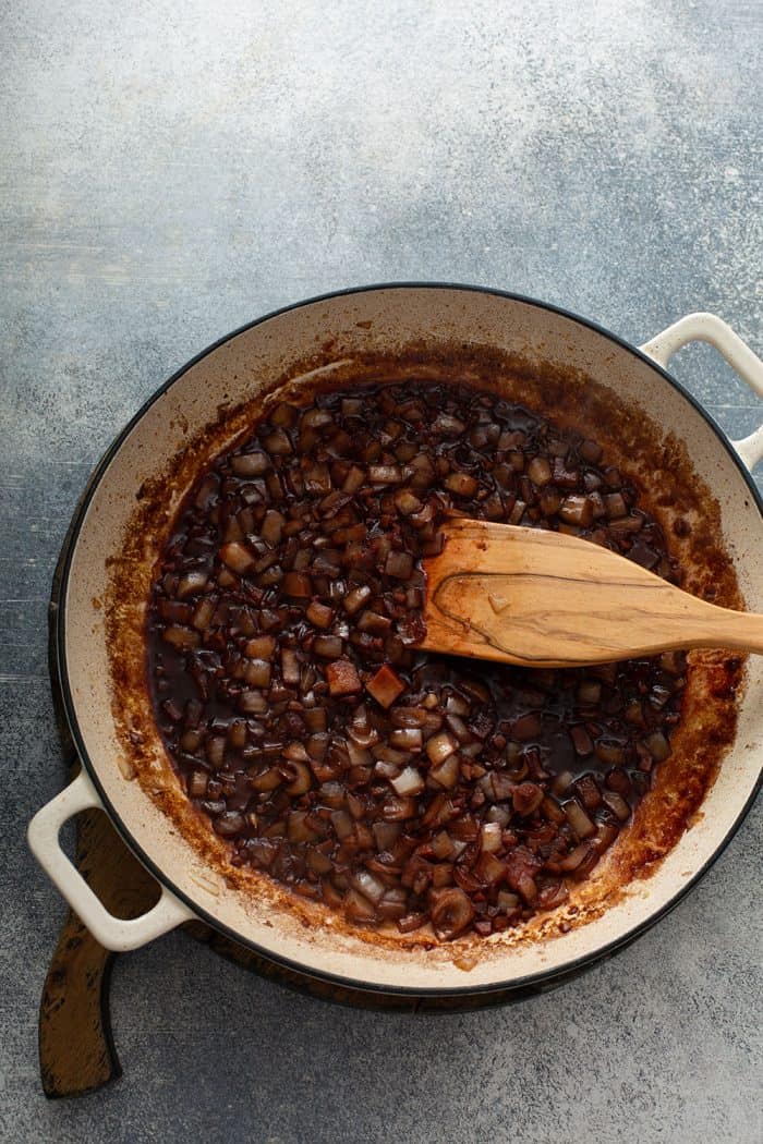 Onions and garlic sauteed with red wine in a dutch oven