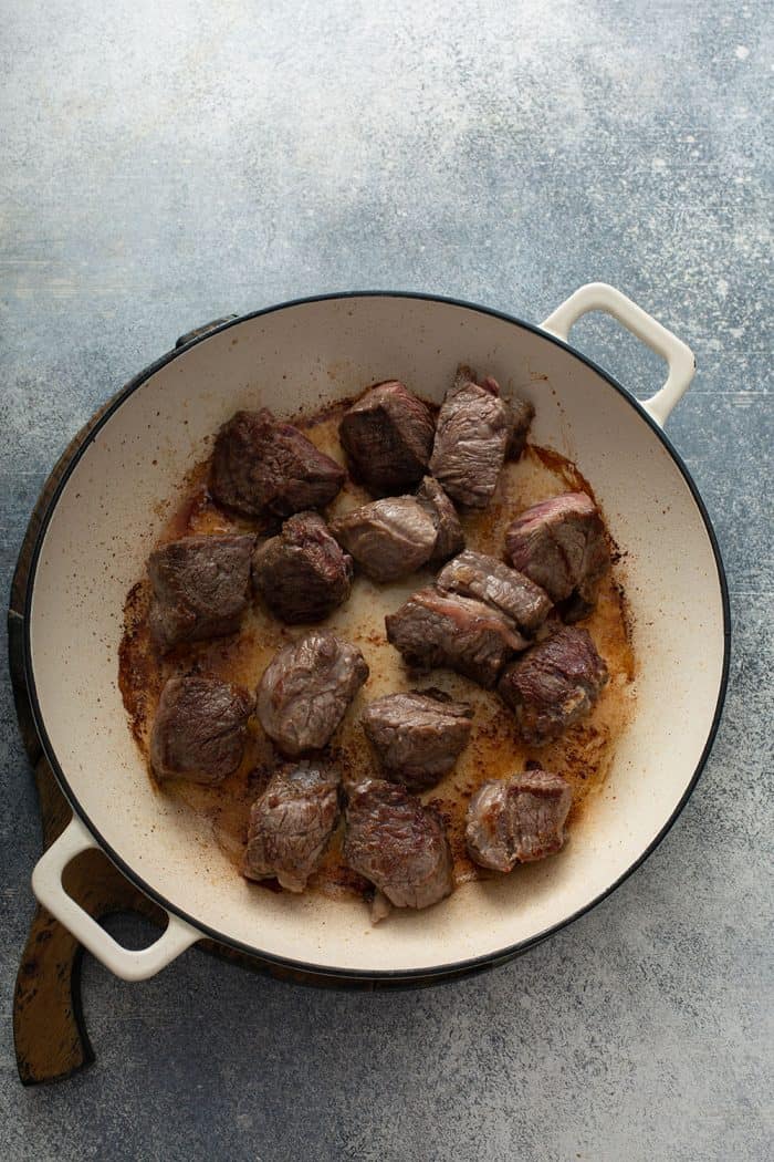 Chunks of stew meat browned in a dutch oven