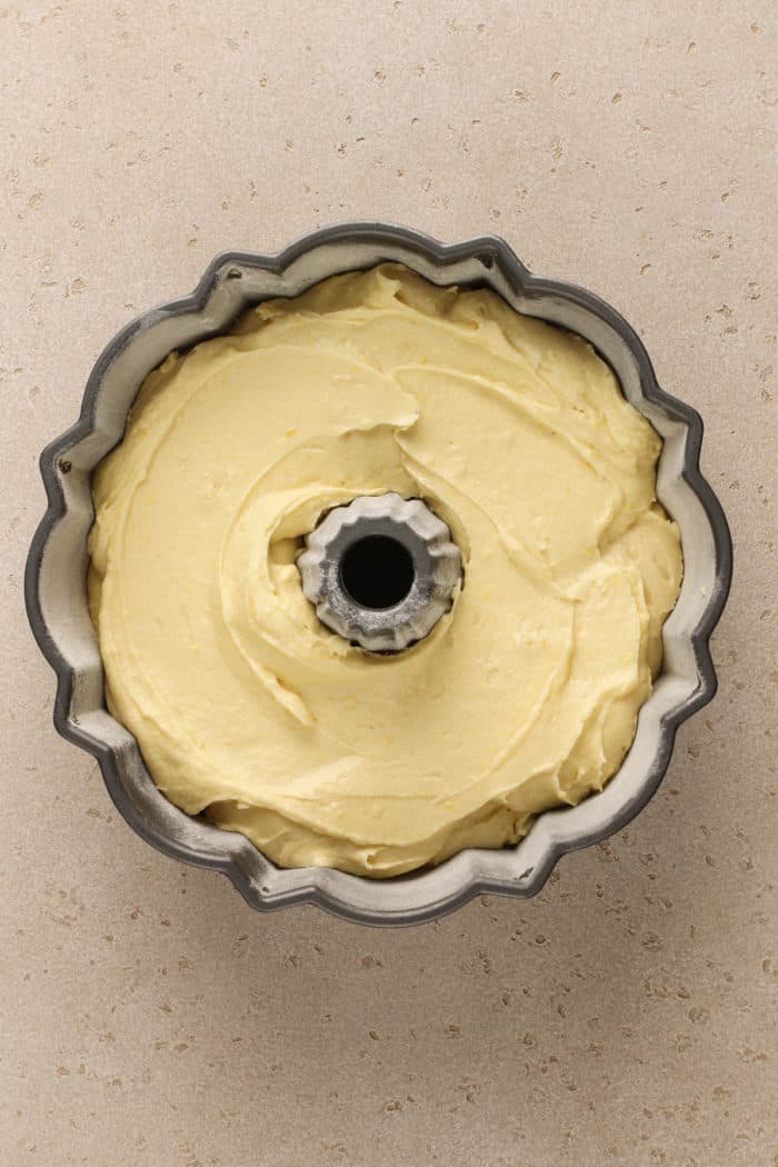Batter for cream cheese pound cake spread in a bundt pan, ready to be baked.