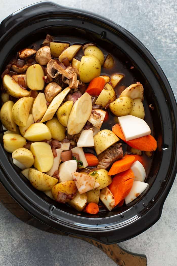 Ingredients for beef and barley stew in a slow cooker, ready to be cooked