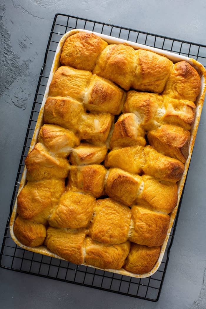 Baked pecan sticky buns in a baking pan on a wire rack