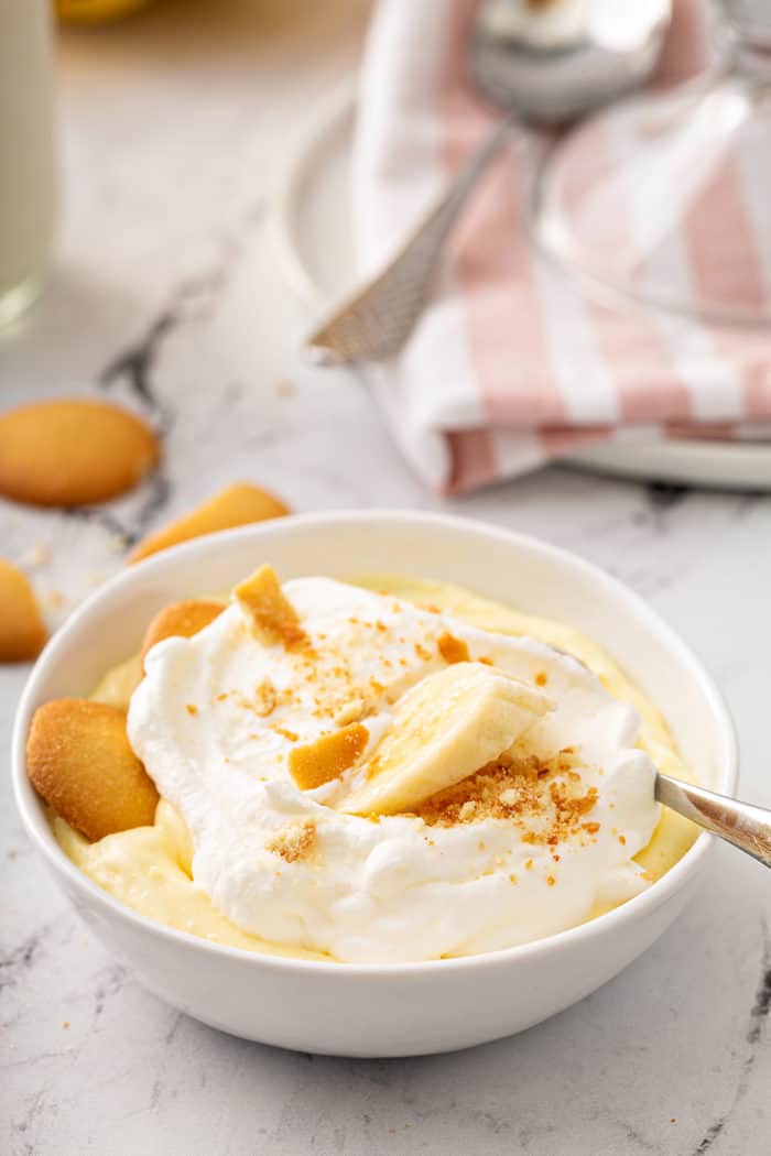 Banana pudding in a white bowl with a spoon in it