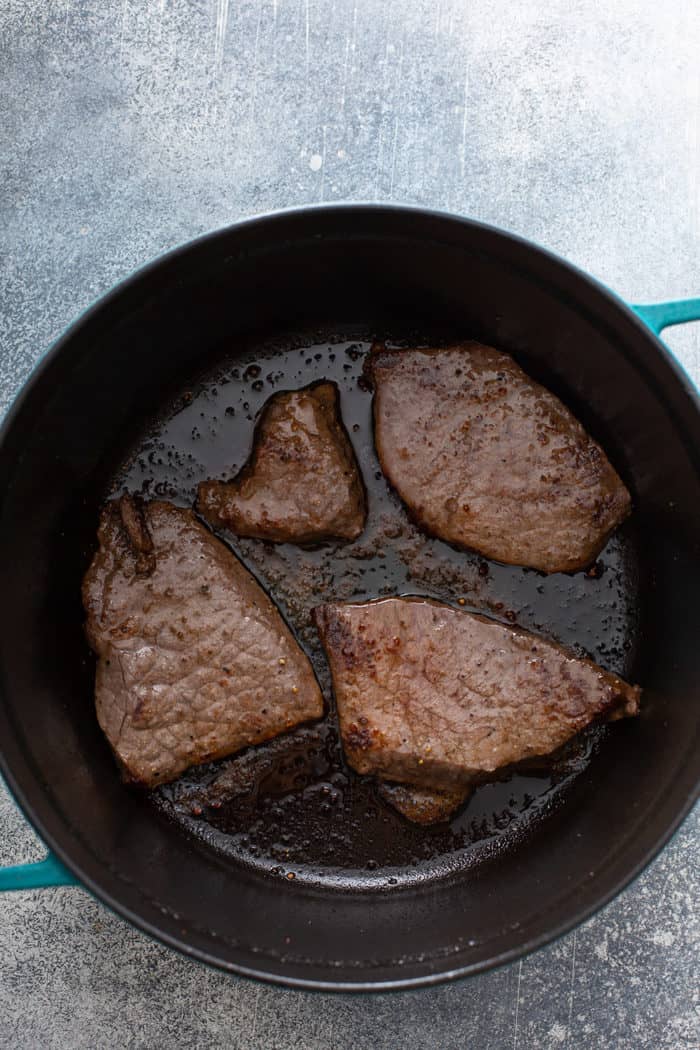 Steak searing in the bottom of a dutch oven for beef stroganoff