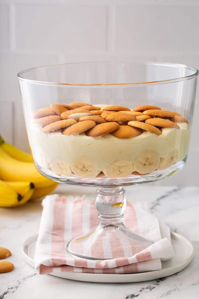 Layer of banana pudding in a trifle dish topped with a layer of nilla wafer cookies