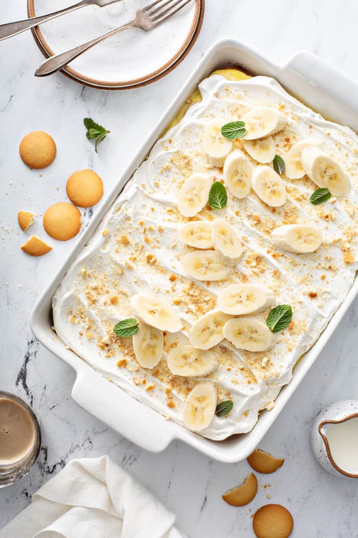 Overhead view of assembled banana pudding poke cake topped with Nilla Wafer crumbs and slices of banana