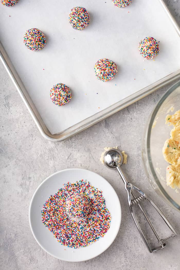 Balls of funfetti cookie dough rolled in nonpareils