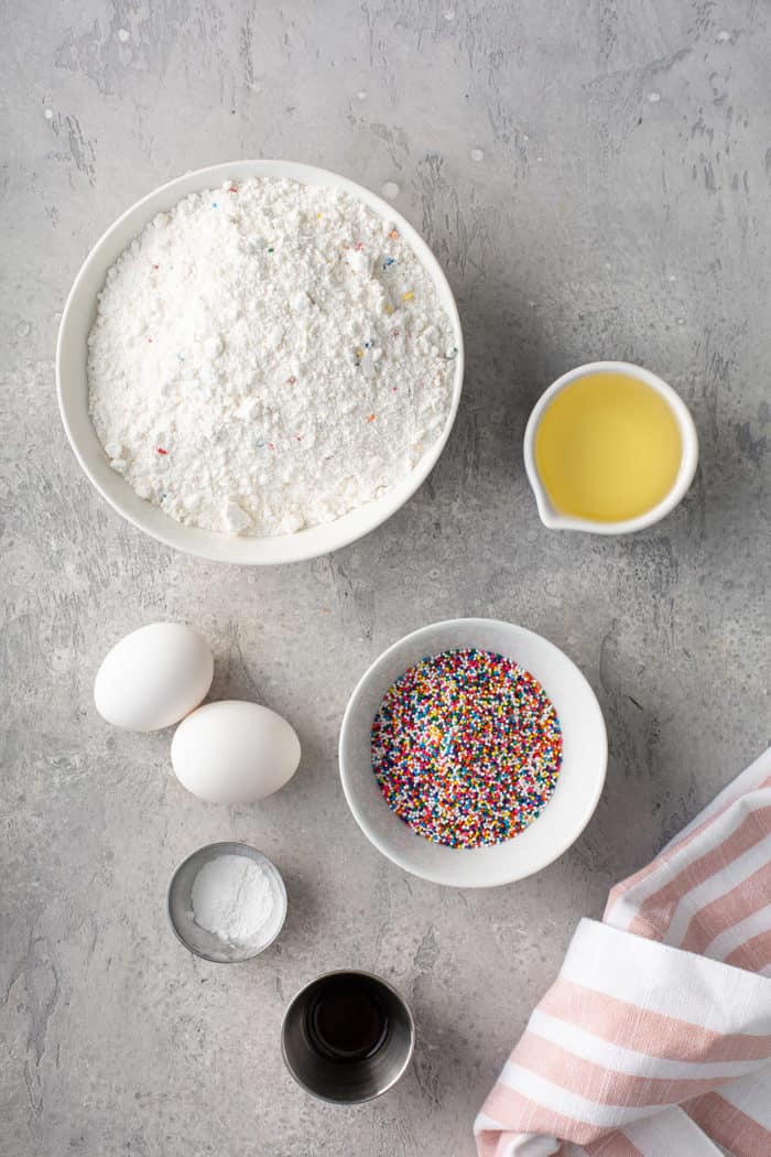 Ingredients for funfetti cookies on a gray countertop