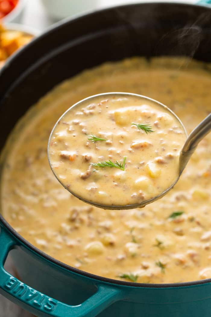 Ladle holding up a spoonful of cheeseburger soup