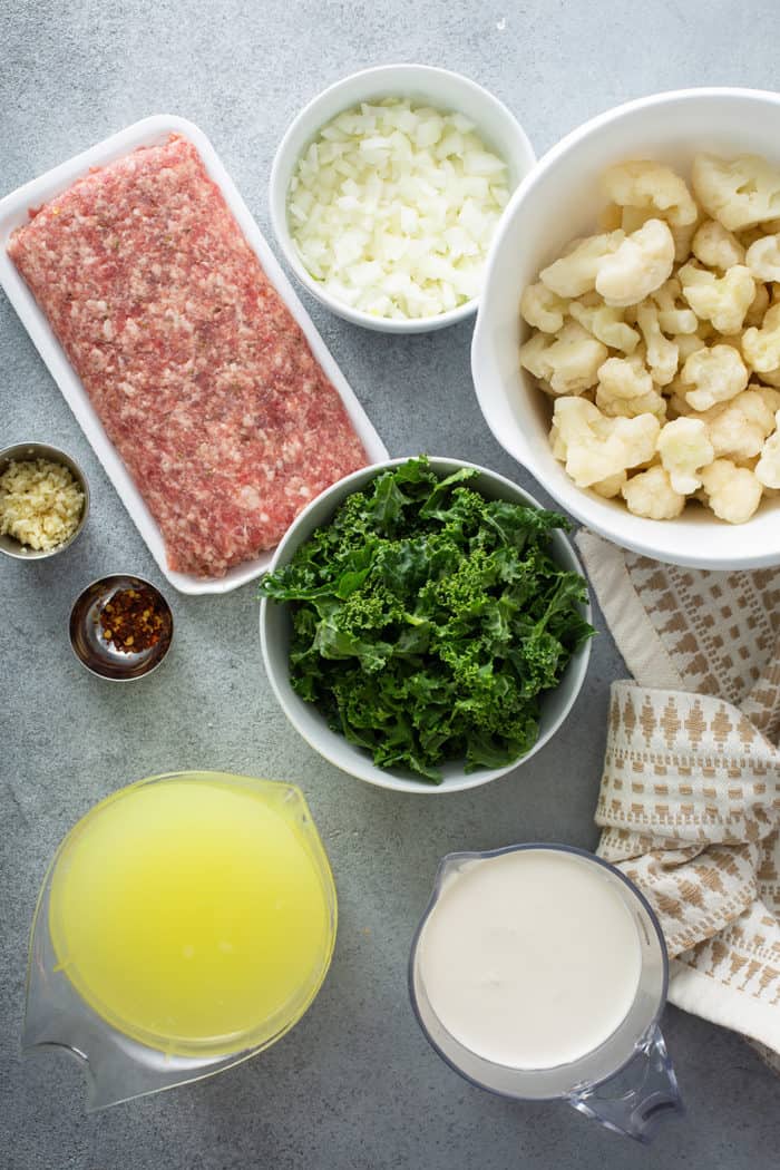 Ingredients for low carb zuppa toscana arranged on a gray countertop