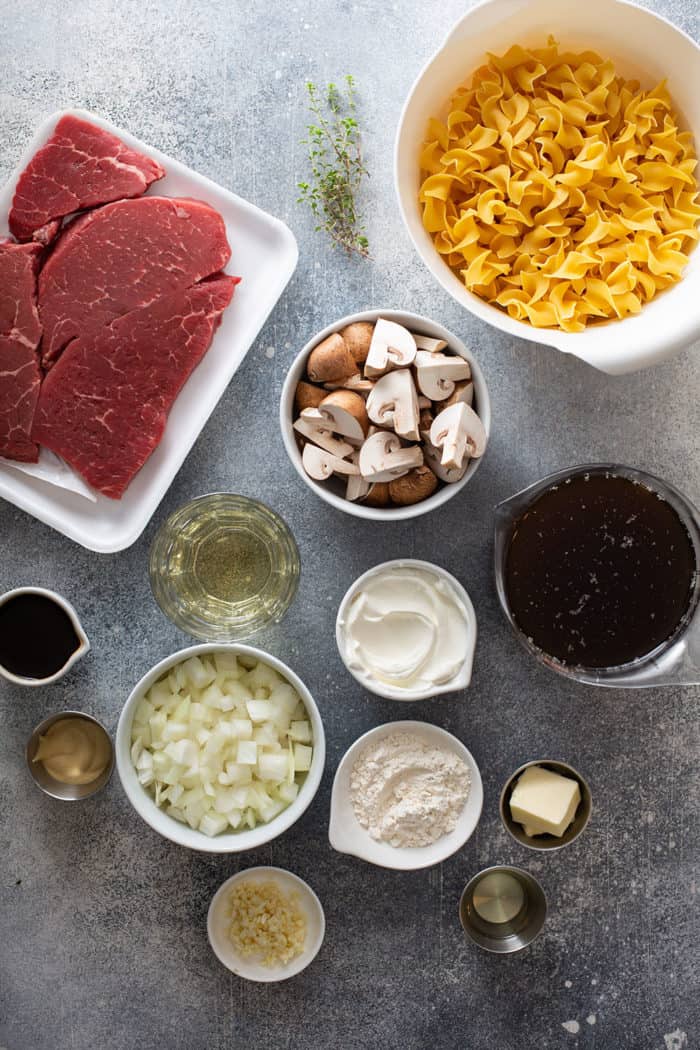 One-pot beef stroganoff ingredients arranged on a gray counter