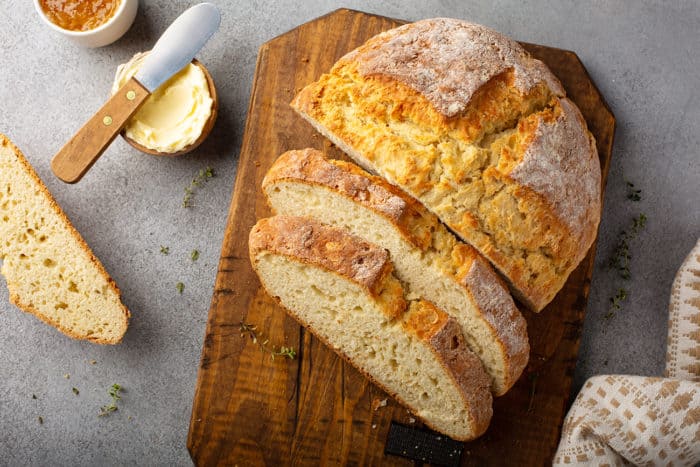 Overhead view of a sliced loaf of irish soda bread on a wooden cutting board