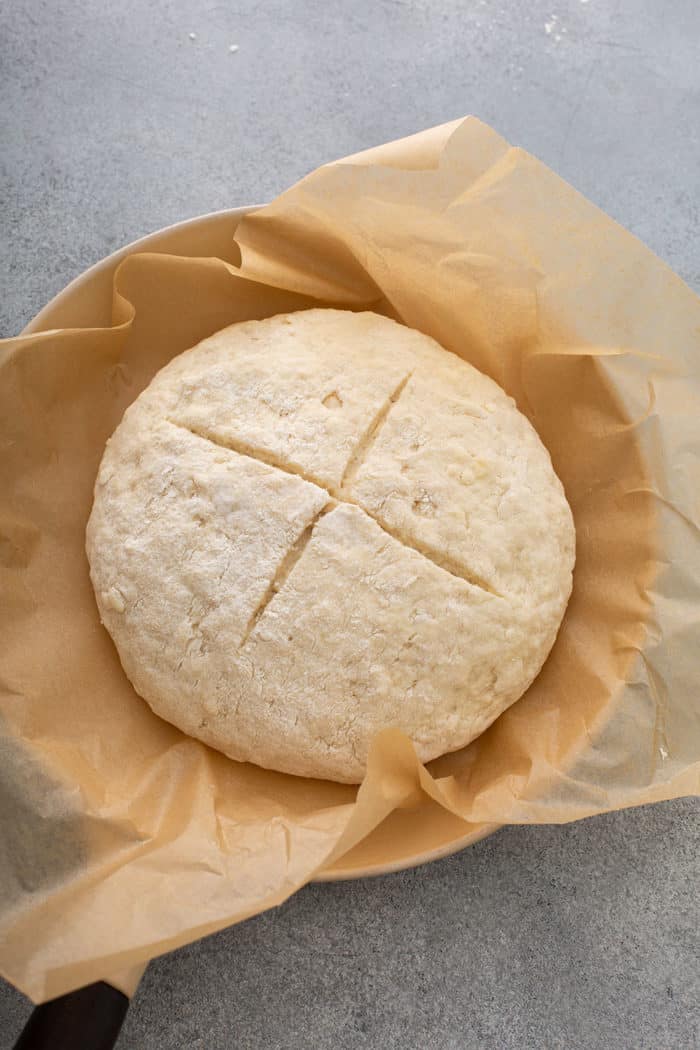 Loaf of soda bread dough in an iron skillet, ready to be baked