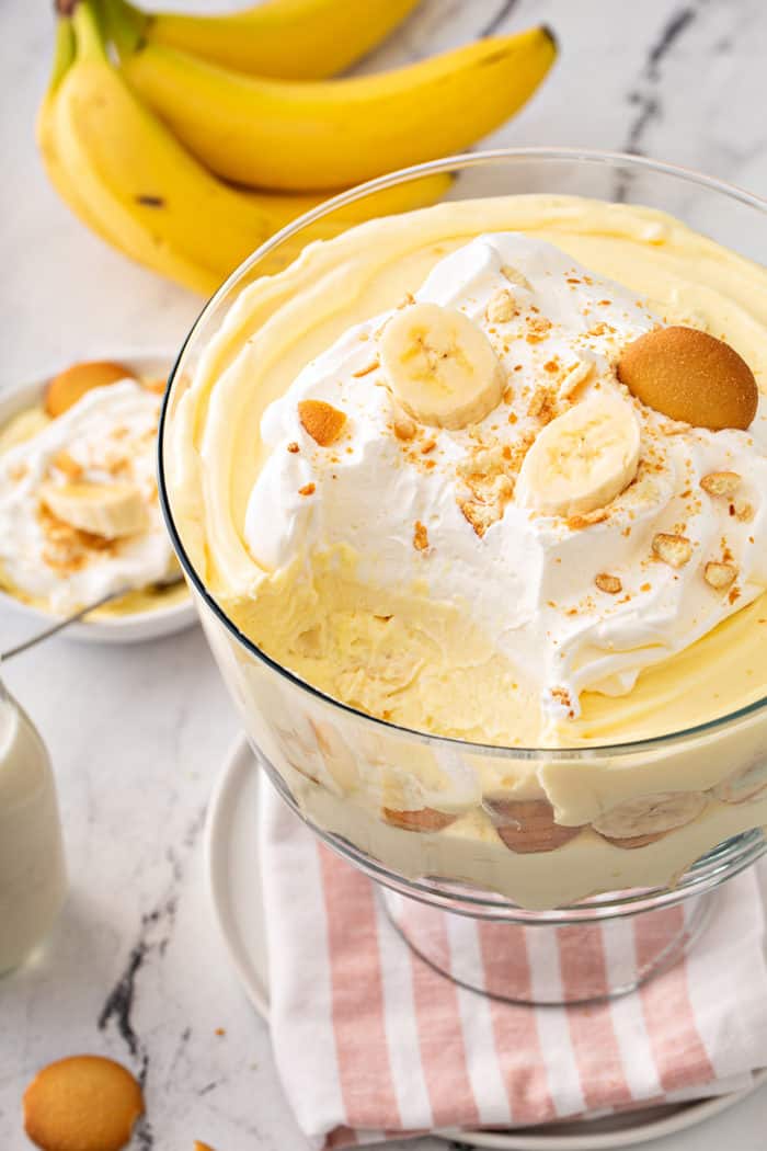 Banana pudding in a trifle dish with a spoonful taken out of the top