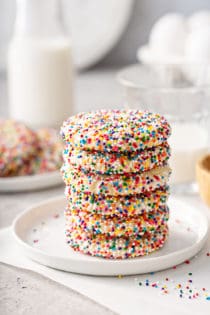 Six funfetti cookies stacked on a white plate