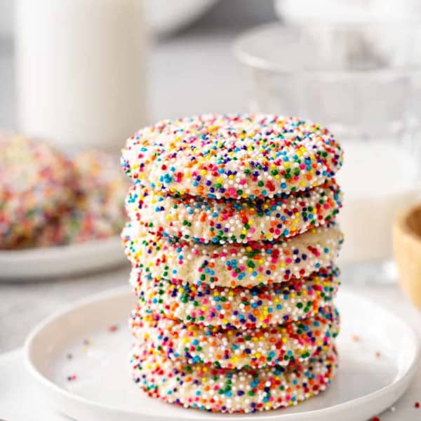 Six funfetti cookies stacked on a white plate