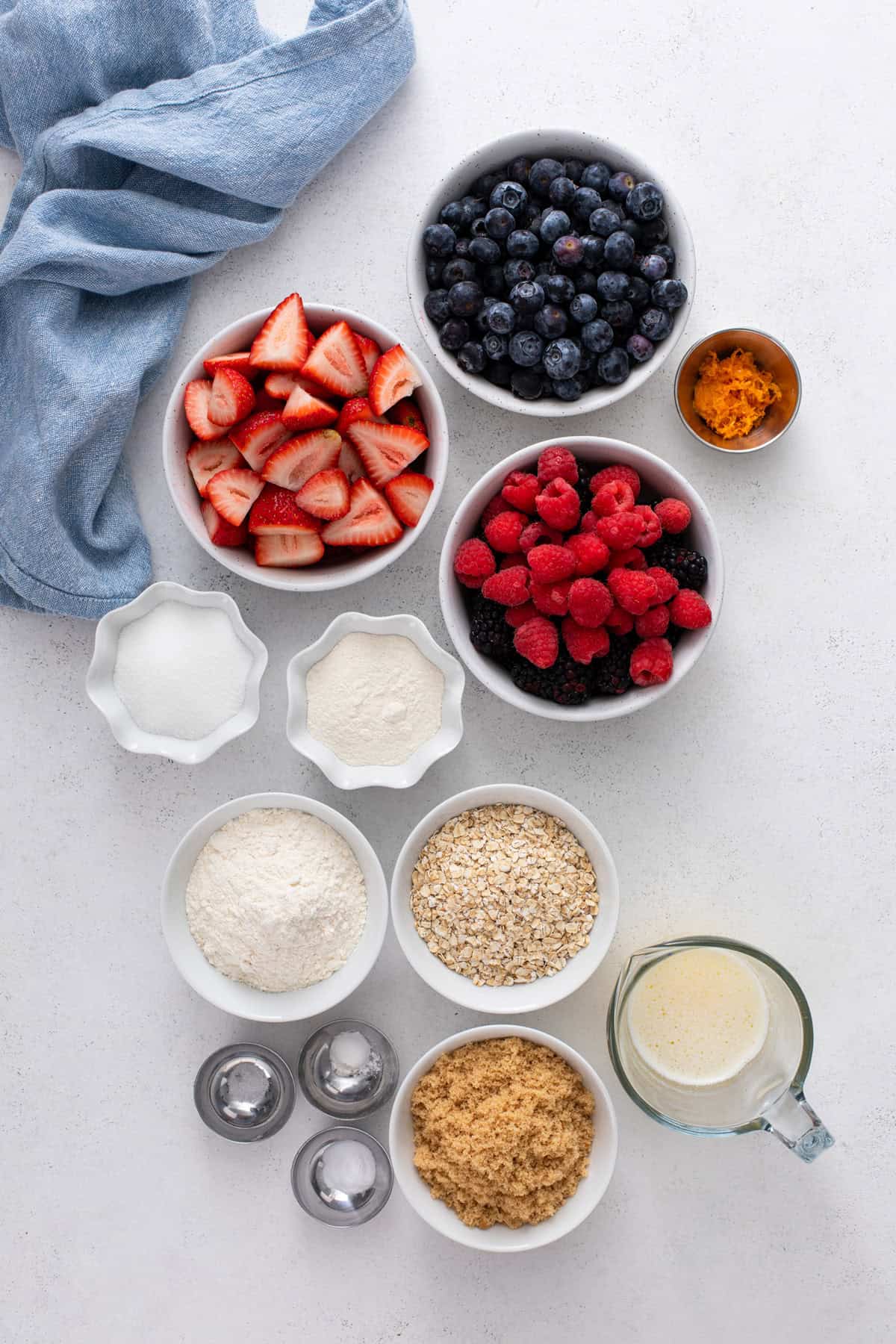 Ingredients for mixed berry crisp arranged on a countertop.