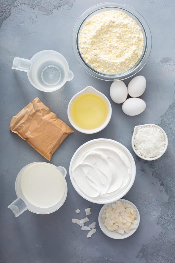 Ingredients for coconut poke cake arranged on a gray countertop