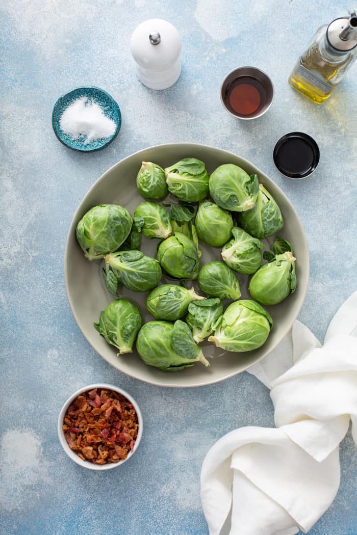 Ingredients for air fryer brussels sprouts arranged on a blue countertop