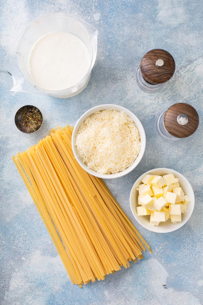 Ingredients for fettuccine alfredo on a blue countertop