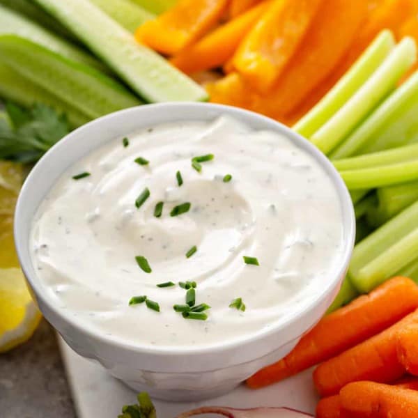 Bowl of ranch dip nestled among cut veggie sticks