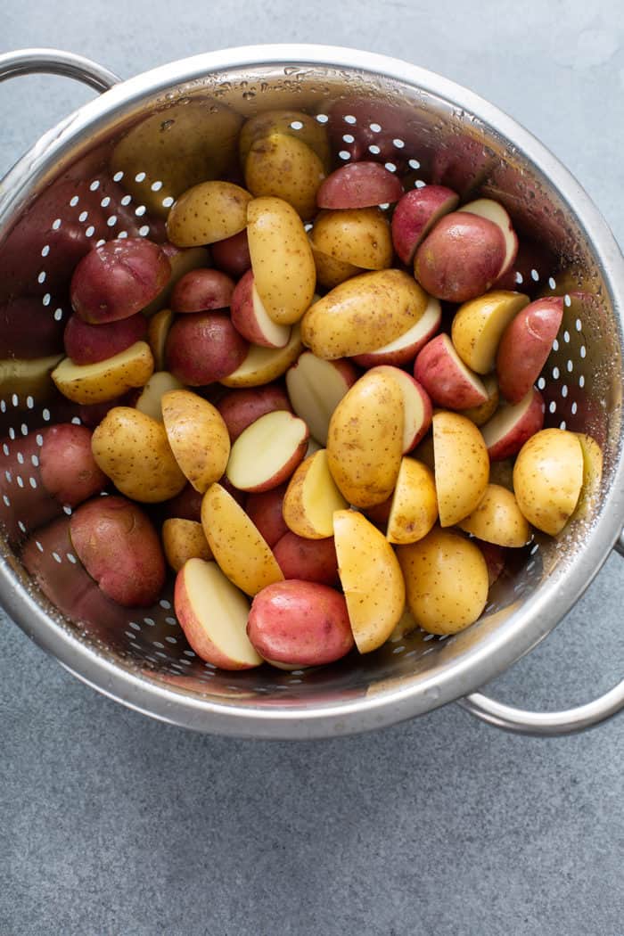 Sliced baby potatoes in a metal colander