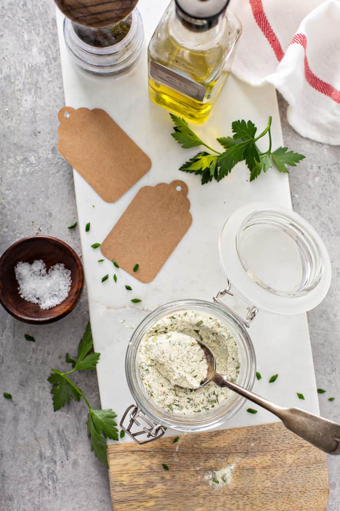 Overhead view of ranch seasoning in a glass jar, next to gift tags for gifting