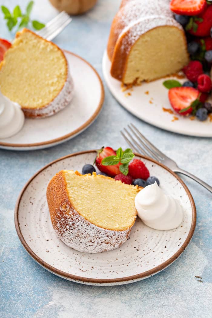 Plated slices of whipping cream cake, garnished with whipped cream and fresh berries