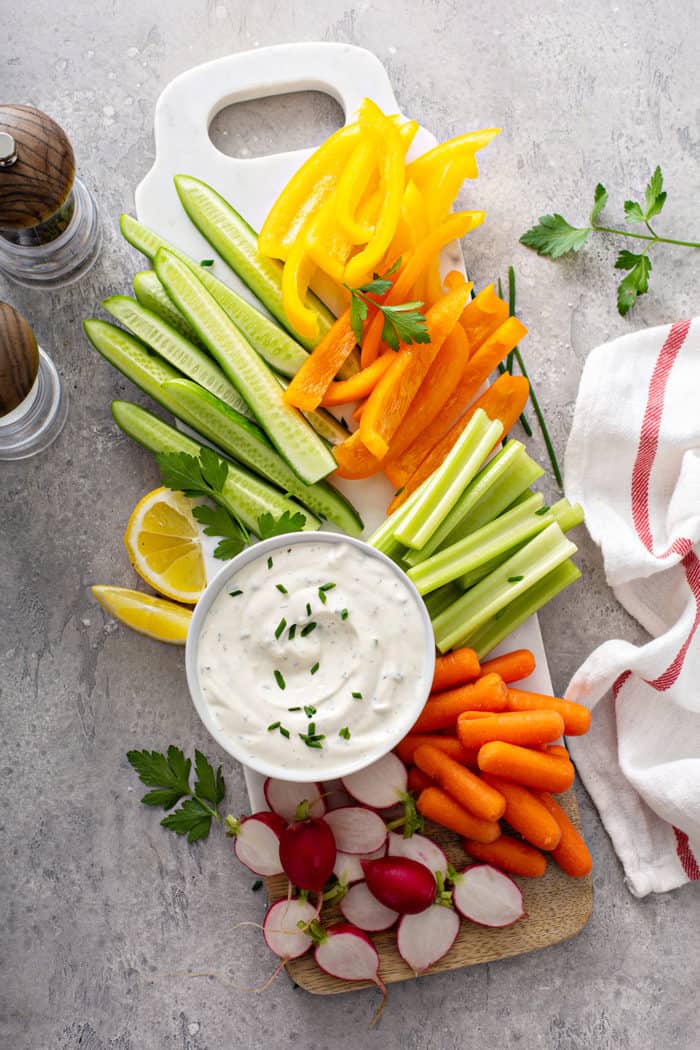 Overhead view of a bowl of ranch dip on a platter of crudites