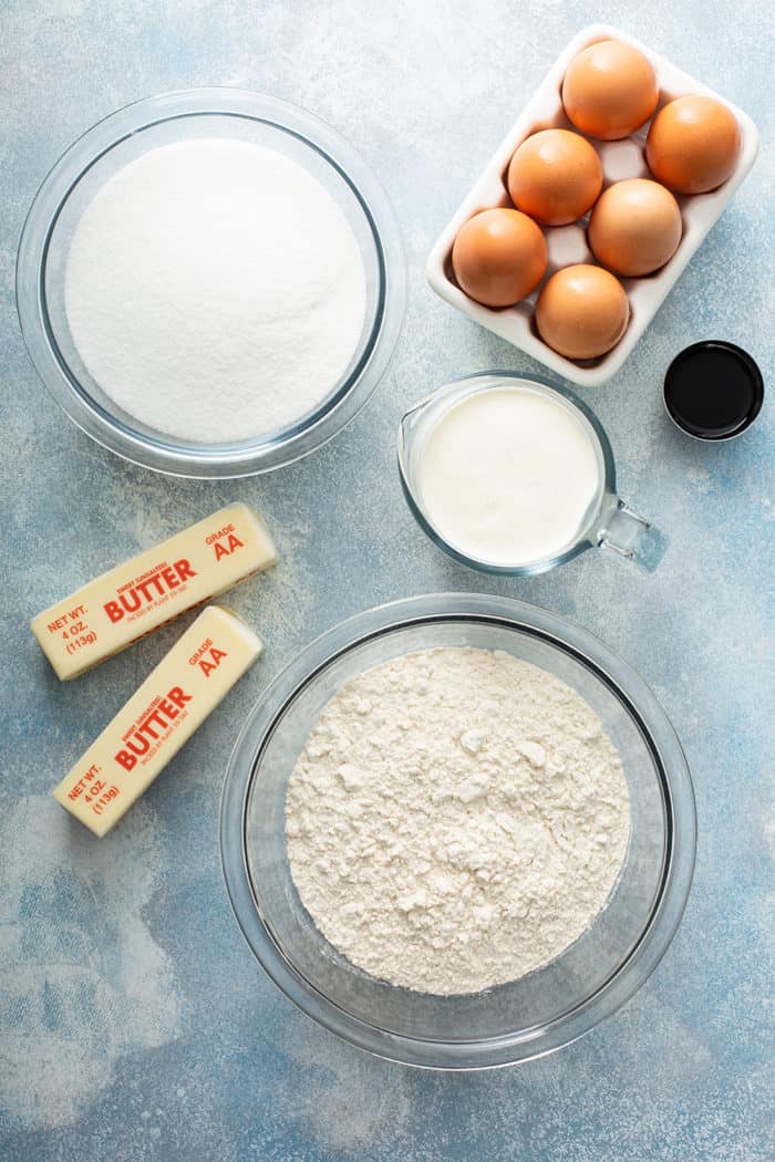 Ingredients for whipping cream cake on a blue countertop