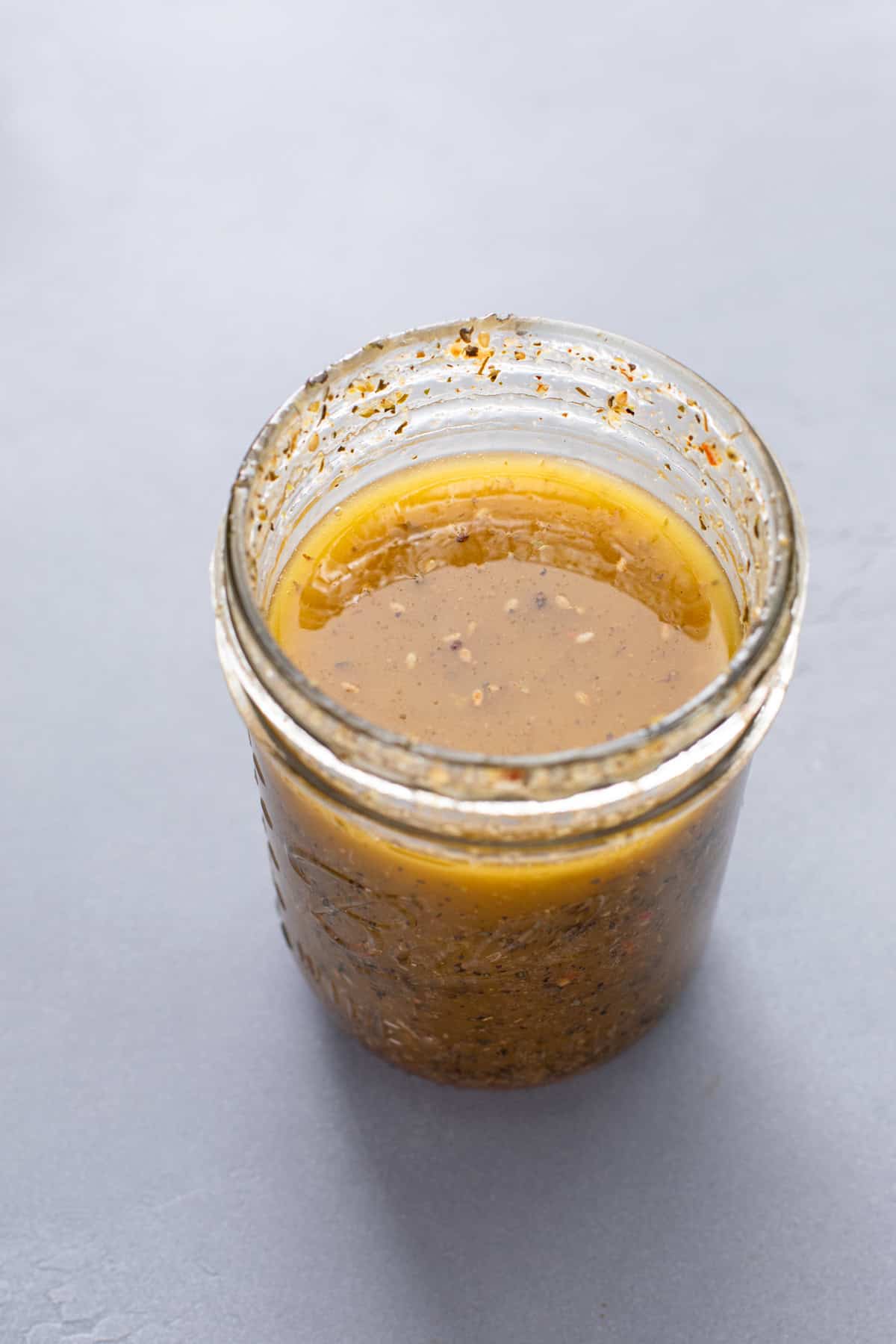 Greek salad dressing combined in a mason jar.