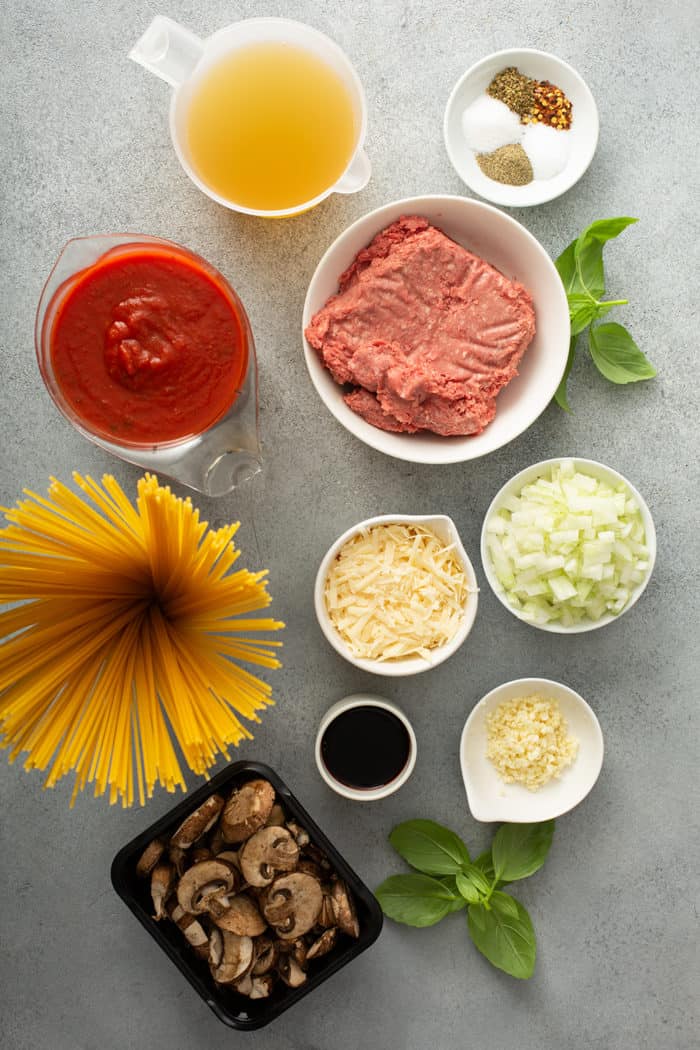 Ingredients for one-pot spaghetti arranged on a gray countertop