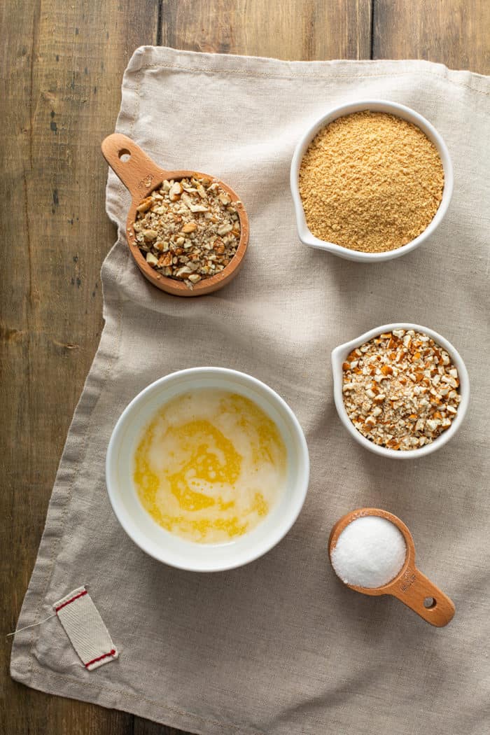 Ingredients for a pretzel and graham cracker pie crust on a kitchen towel