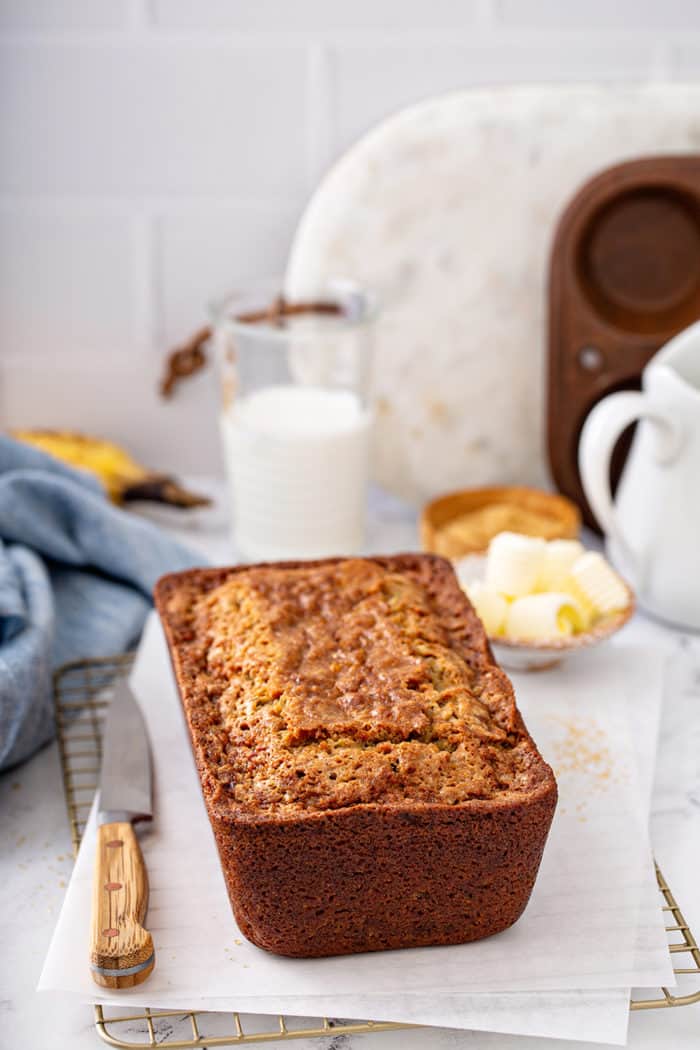 Baked loaf of zucchini banana bread set on a piece of parchment paper