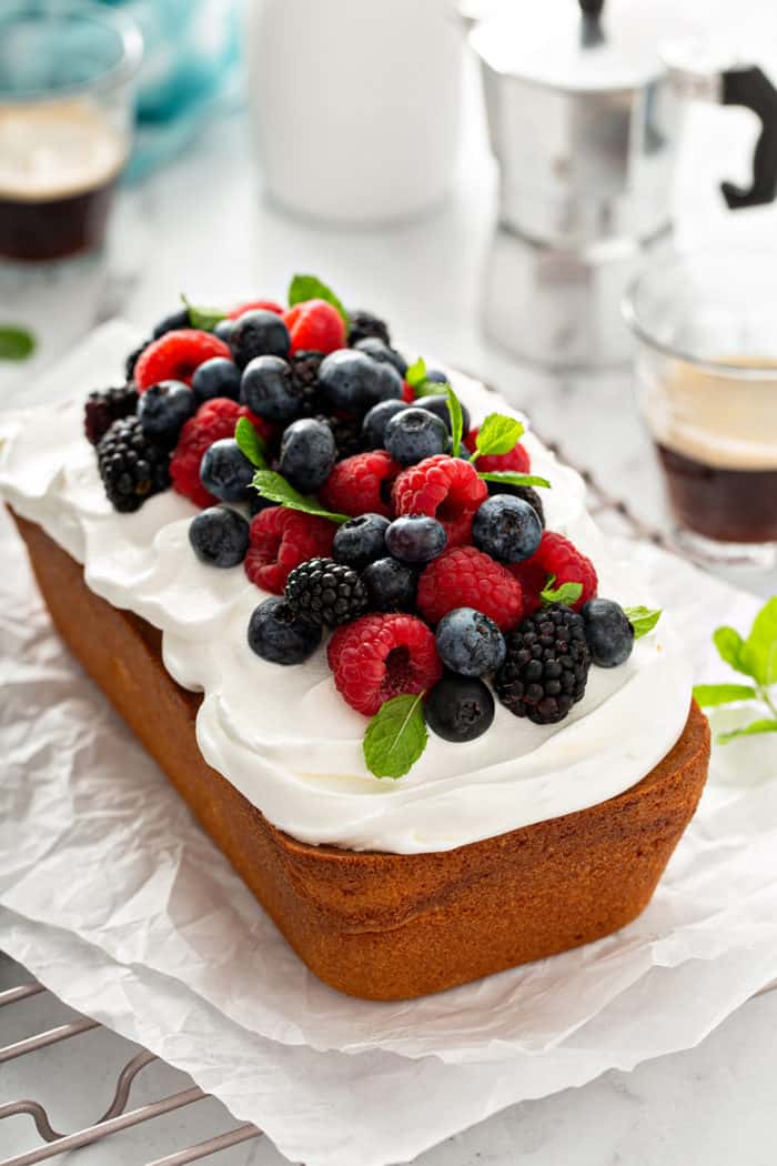 Loaf of lemon whipping cream cake topped with whipped cream and fresh berries