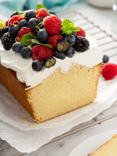 Cross view of sliced lemon whipping cream cake, topped with whipped cream and berries