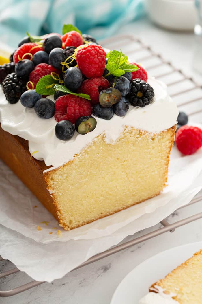 Cross view of sliced lemon whipping cream cake, topped with whipped cream and berries